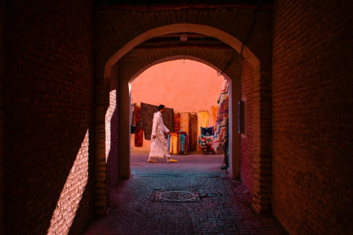 A person walks through an arched passage.